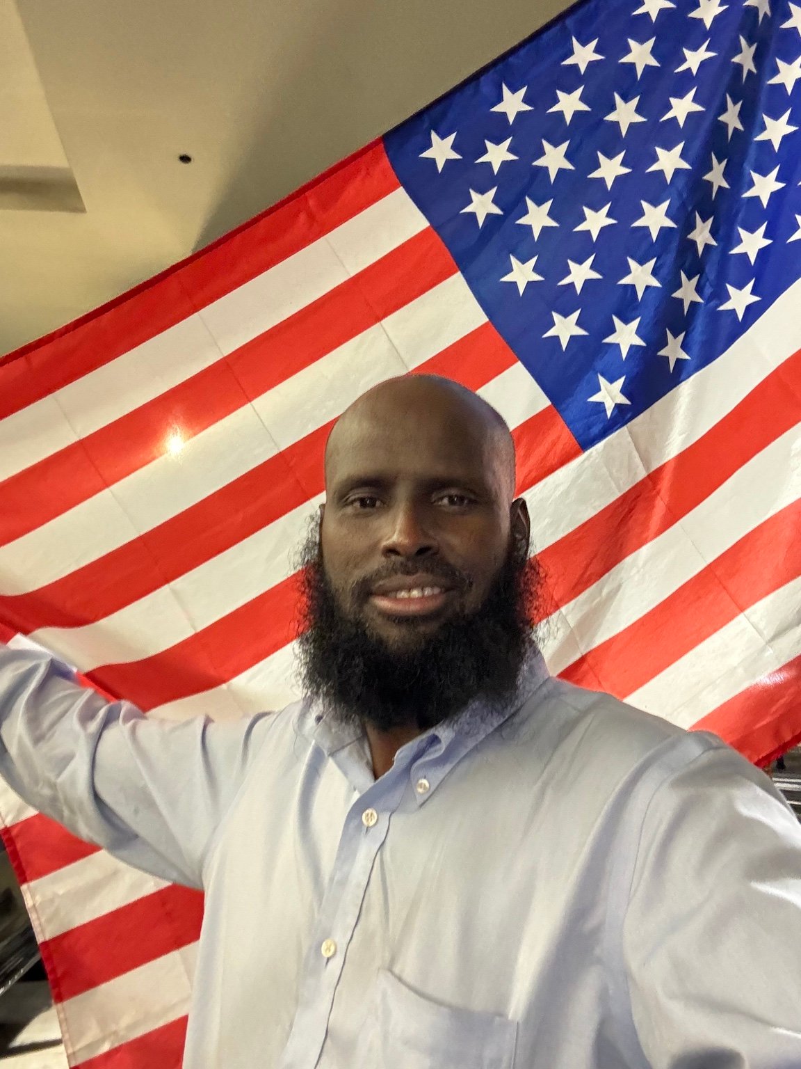 Ahmed Muse Abdulle (Idaawaqaca) with the American flag.