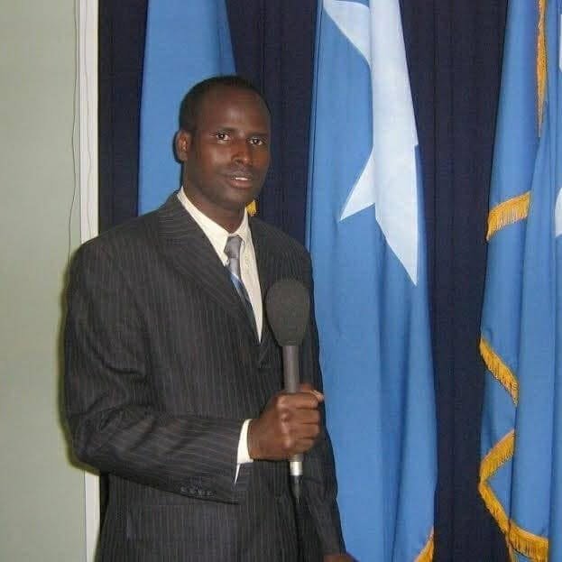 Ahmed Muse Abdulle (Idaawaqaca) oo makarafoon haya, calanka Soomaaliya hortiisa